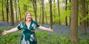 Hannah with outstretched arms in blue bell wood