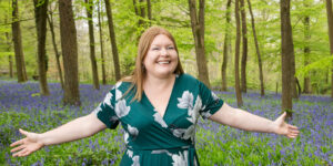 Hannah with outstretched arms in blue bell wood