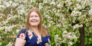 Hannah in front of apple blossom tree.