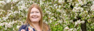 Hannah in front of apple blossom trees