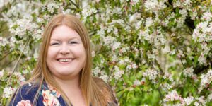 Hannah in front of apple blossom trees