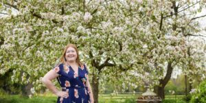 Hannah in front of Apple tree in blossom.