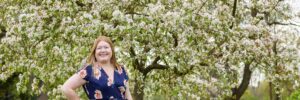 Hannah in front of apple blossom tree