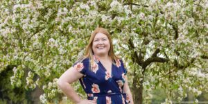 Hannah in front of Apple tree in blossom.