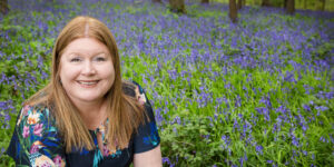 Hannah knelt down in bluebell woods.