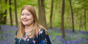 Hannah looking into distance in bluebell wood.