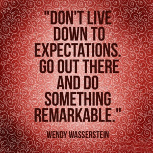 Quote from Wendy Wasserstein quote on patterned red background. Don't live down to expectations. Go out there and do something remarkable.